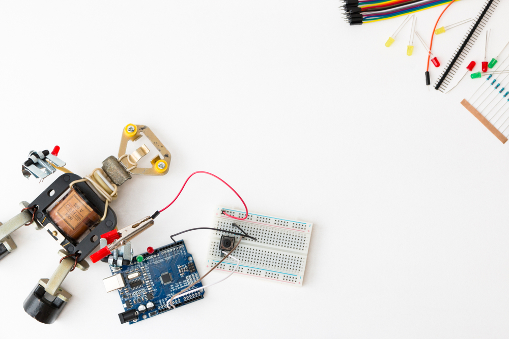 A metal robot and an electronic board that can be programmed. Robotics and electronics. Lab in the school. Mathematics, engineering, science, technology, computer code. STEM education for kid.