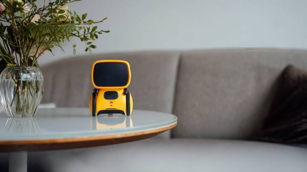 yellow ai toy robot on table in living room at home